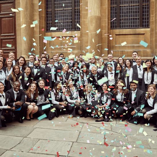 students celebrating graduation in sub fusc with confetti